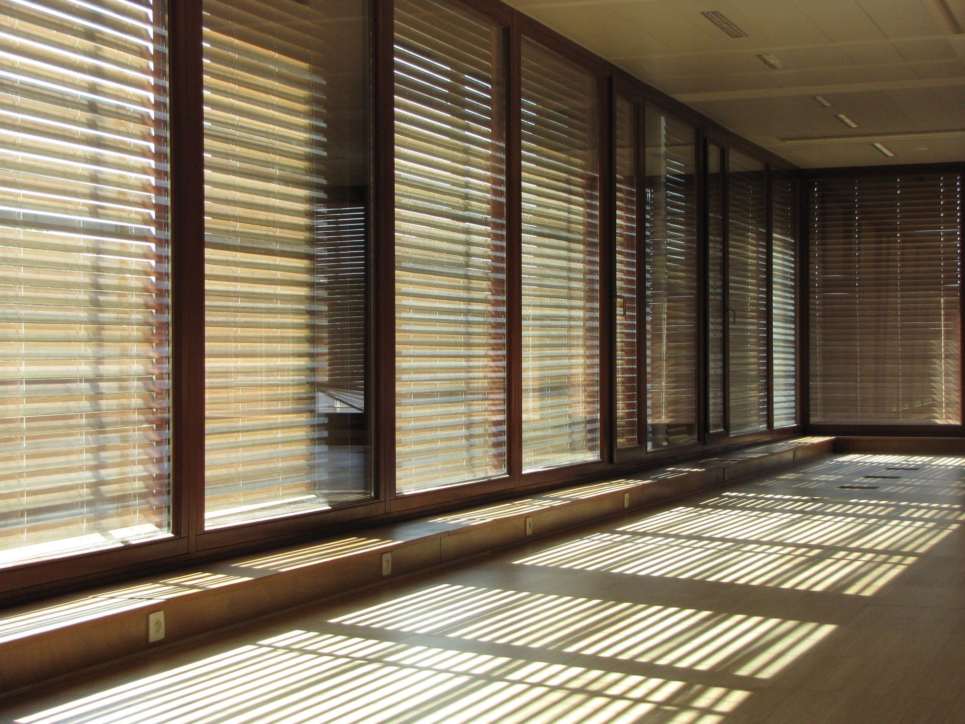 Grote glaspartijen met houten raamprofielen en geïntegreerde zonwering