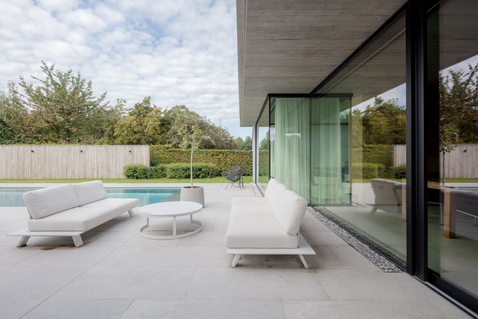 Modern terras met loungemeubelen en grote glaspartijen